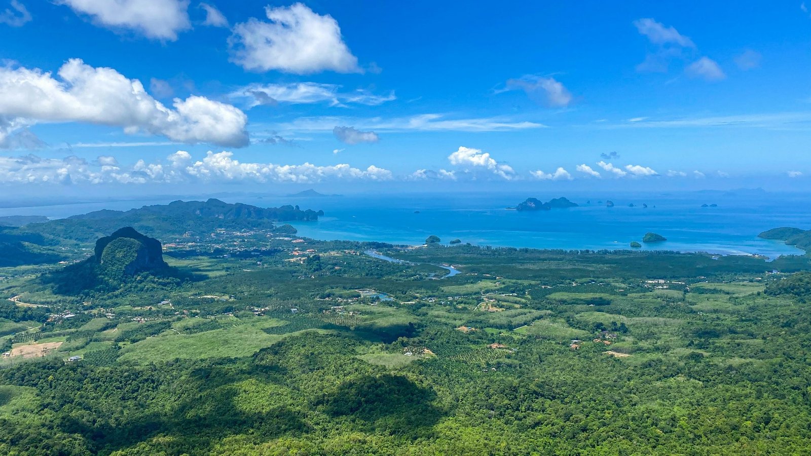 View from the summit of Dragon Crest over green coastal plain, the Andaman Sea and limestone islets