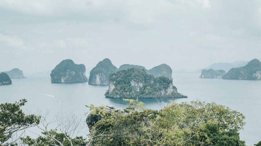 Limestone islets in a grey sea, seen from a forested hilltop