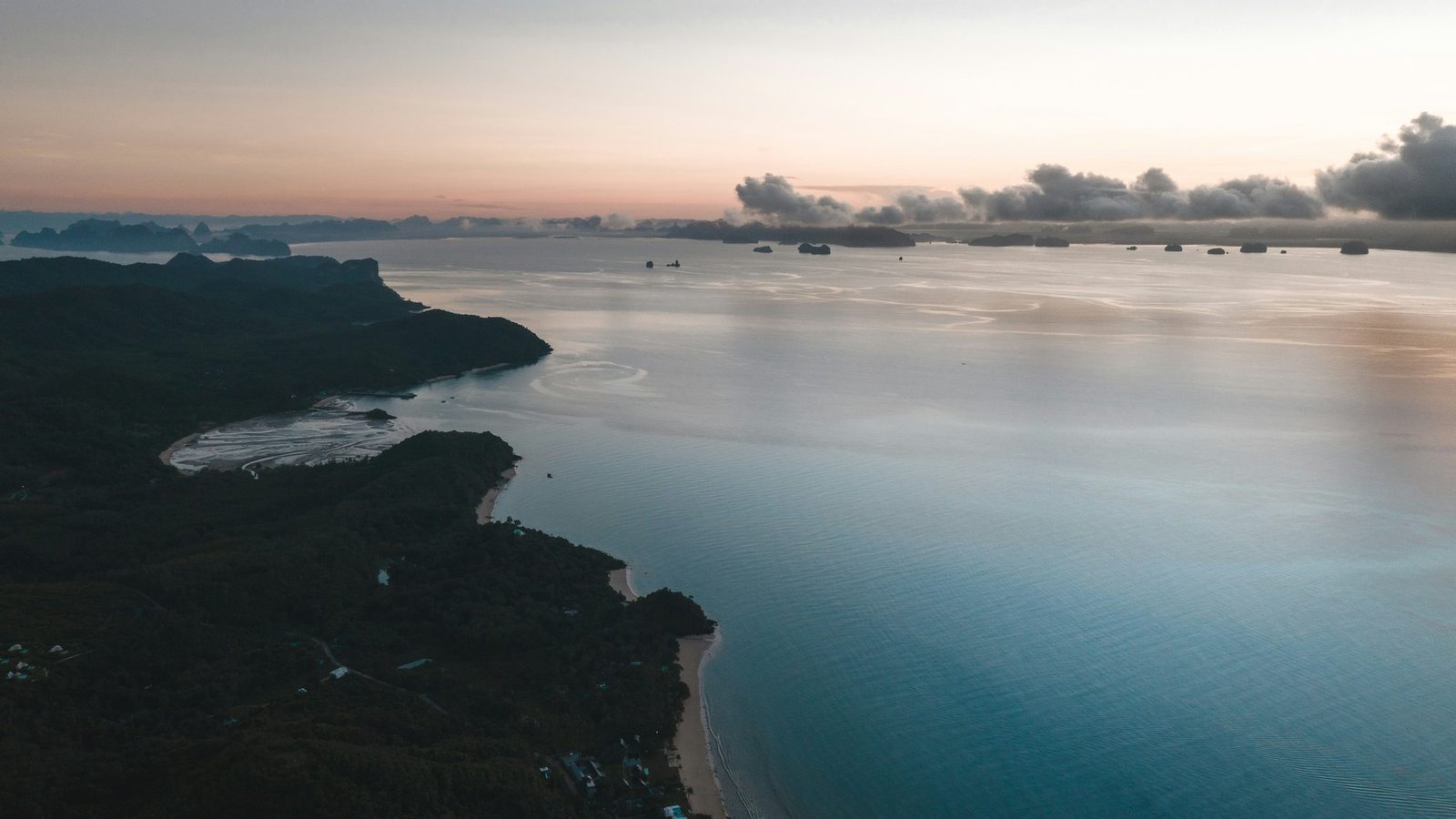 Vue aérienne au crépuscule de la côte boisée de Koh Yao Noi, des îlots calcaires à l'horizon