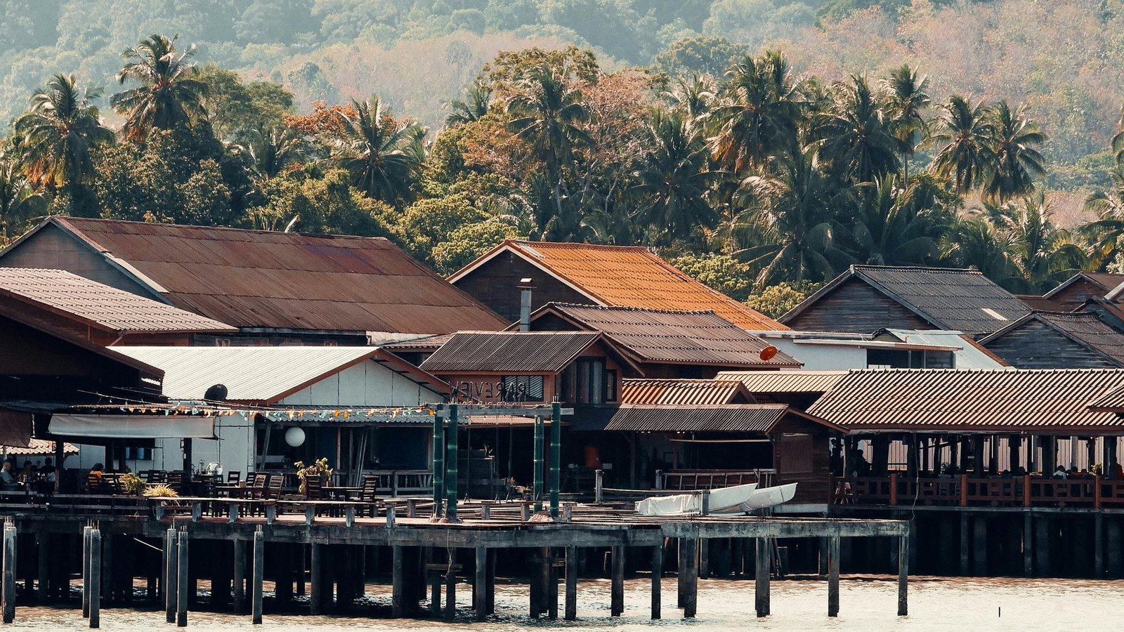 Les maisons en bois sur pilotis de la vieille ville de Lanta, au-dessus de l'eau, collines boisées derrière