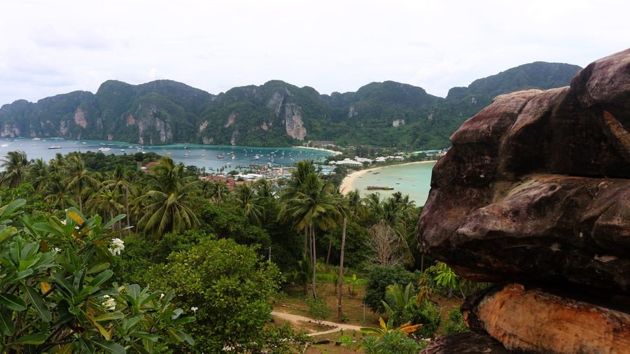 Ton Sai and Loh Dalum bays on either side of Phi Phi Don's isthmus, seen from the hill above, with boulders in front