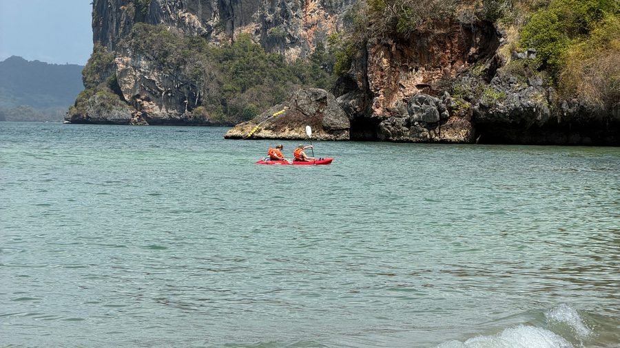 Kayak biplace rouge au pied d'une falaise calcaire, à Krabi
